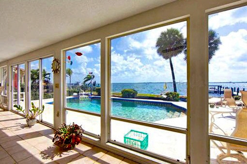 Panoramic windows overlooking the pool and the bay