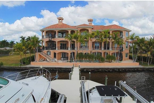 Two-story home in a prime location on the water with boat dock, pool room and much more in Cape Coral