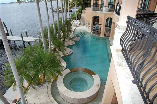 View from the second floor to the pool and dock with boat